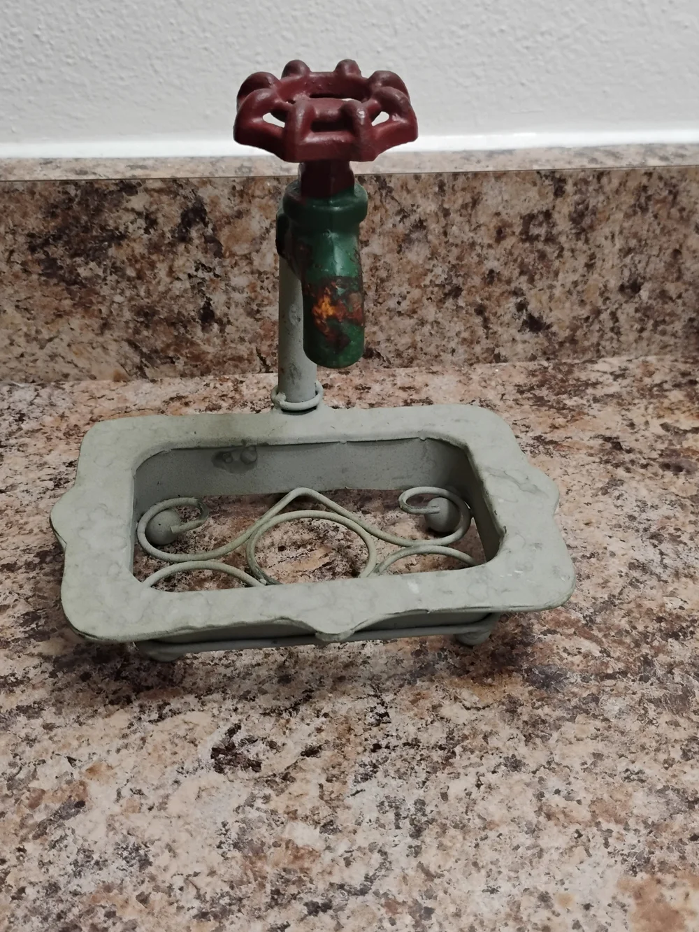 Rustic metal soap dish Vintage with a decorative faucet design and a red handle.